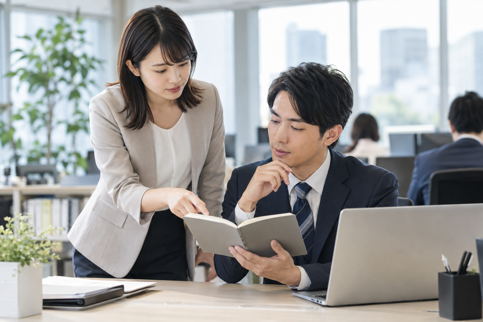 仕事の状況を整理して同僚へ早めに相談するビジネスパーソン