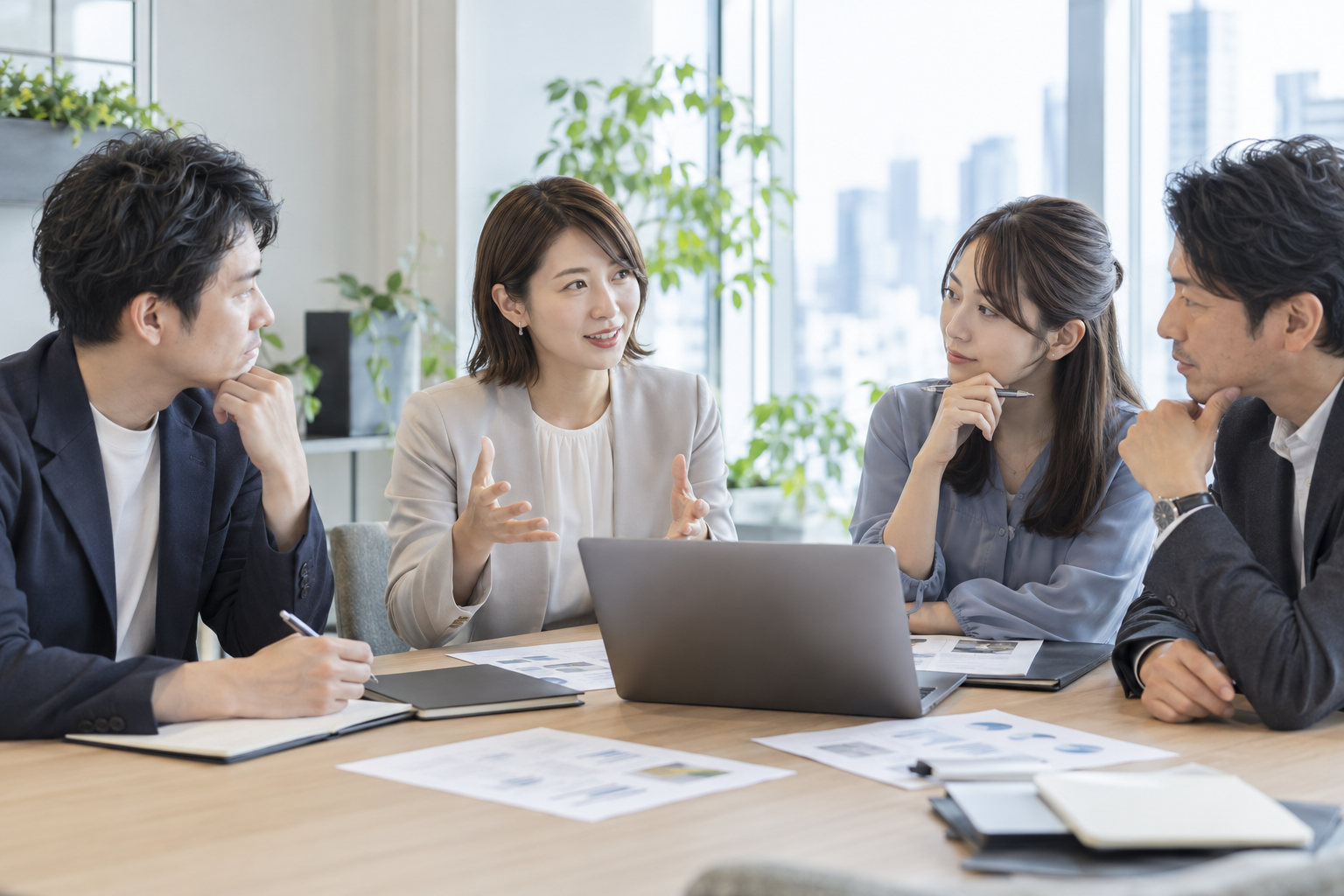 効率化と品質の両立について建設的に話し合う4人のビジネスパーソン